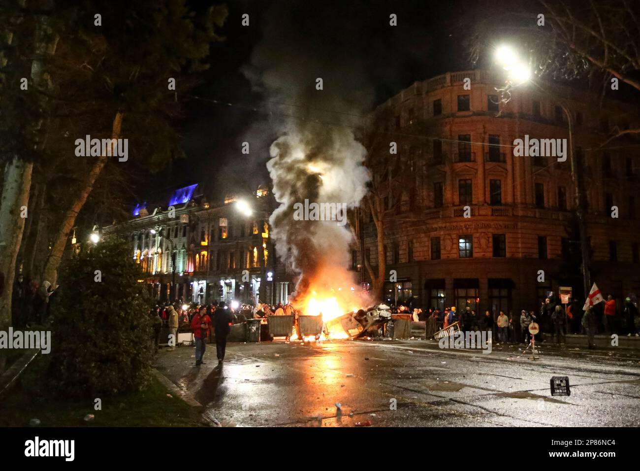 Protesters gather at a barricade with a burning police car, not far from  the Georgian parliament building in Tbilisi, Georgia, Thursday, March 9,  2023. Police in the capital of Georgia used water
