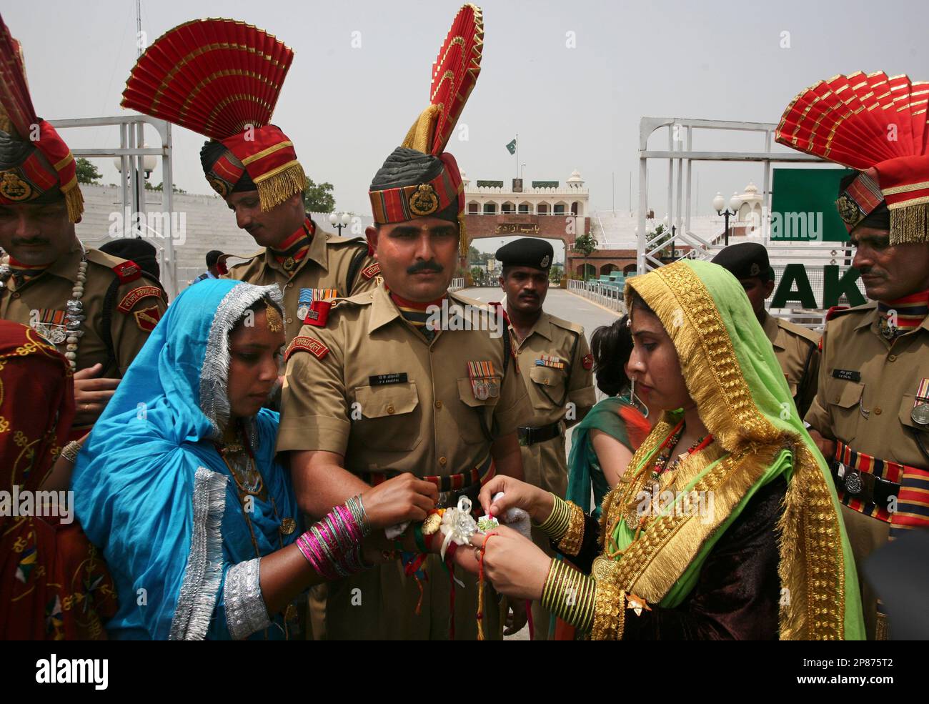 Pakistan Rakhi College students, dressed in traditional attire, tie rakhis on the ...
