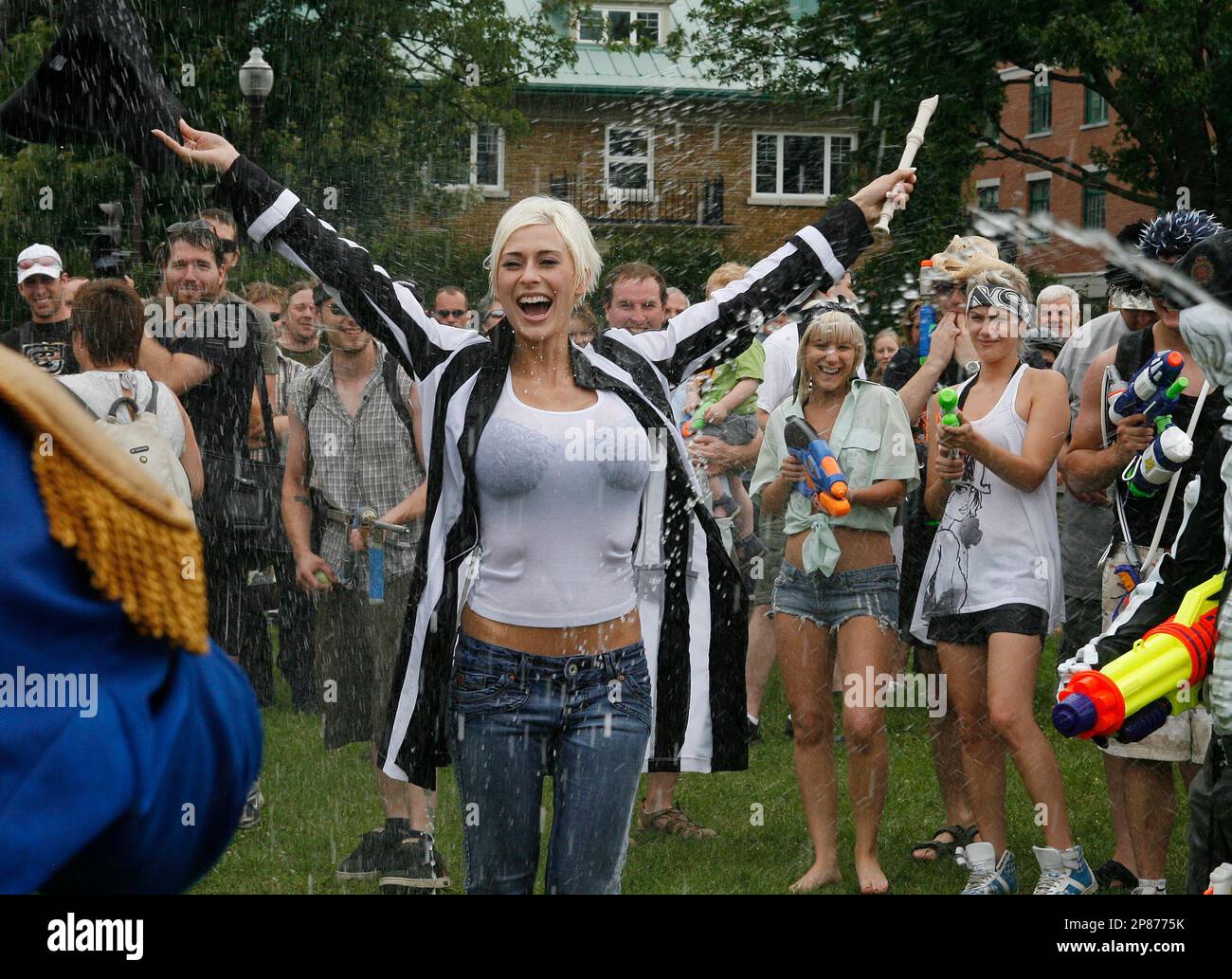 Acting referee Marie-Claude Bopurbonnais, centre, raises her arms before  two groups of people armed with water pistols fight at a mock reenactment  of the battle of the Plaines of Abraham Sunday, Aug.
