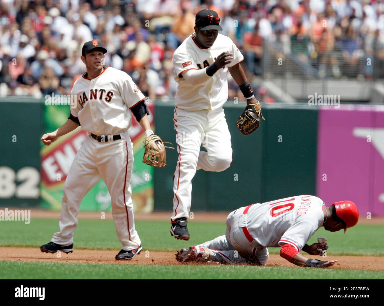 San Francisco Giants shortstop Edgar Renteria, center, helps turn a double  play as Philadelphia Phillies' Ben Francisco, right, is forced out at  second base during the first inning of a baseball game