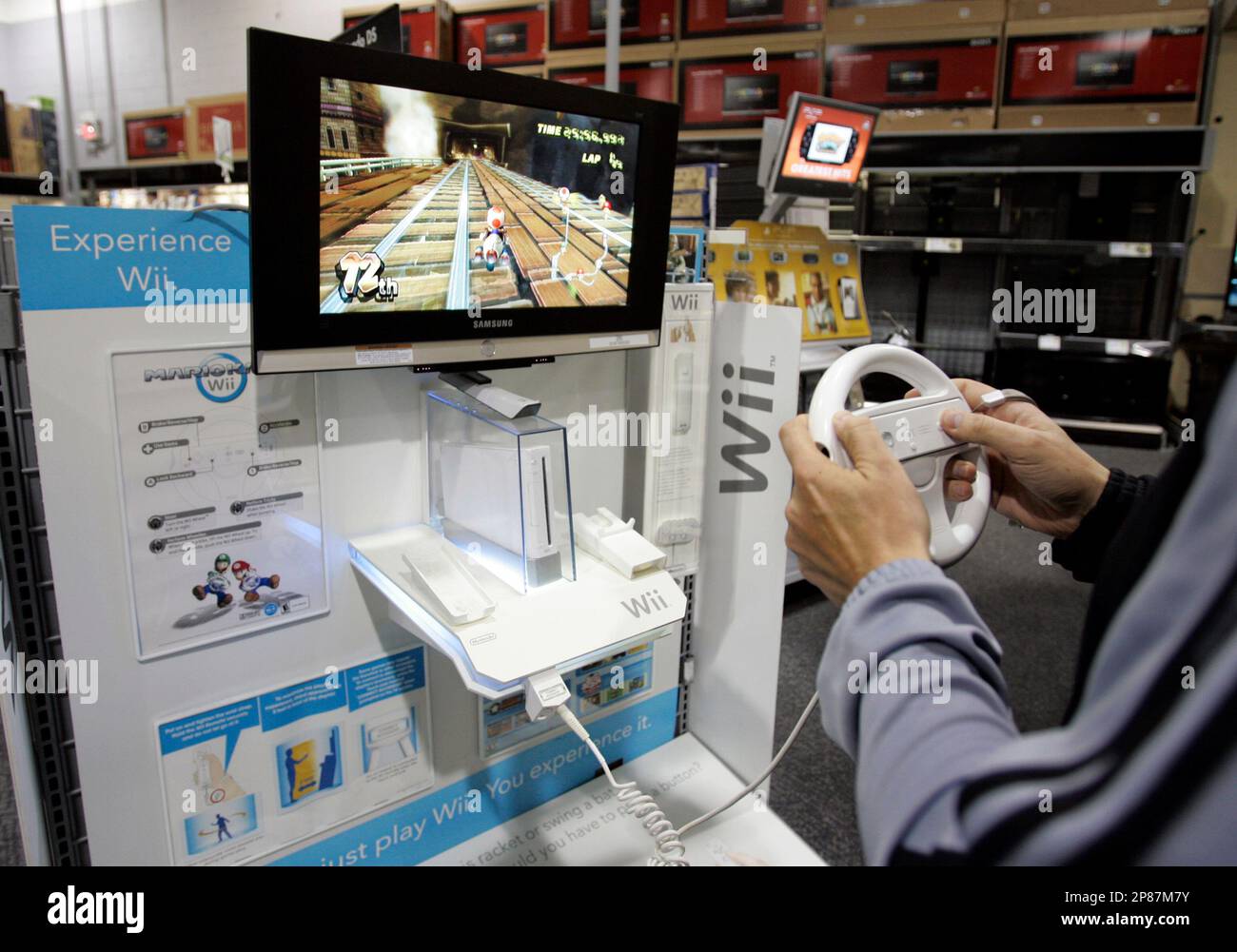 In this photo made Dec. 15, 2008, a customer plays a game on a Nintendo Wii  at Best Buy in Mountain View, Calif. Sharp declines in game console sales  for Nintendo and