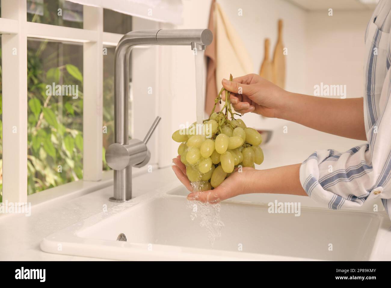 Woman washing grapes under tap water in kitchen sink, closeup Stock Photo Alamy