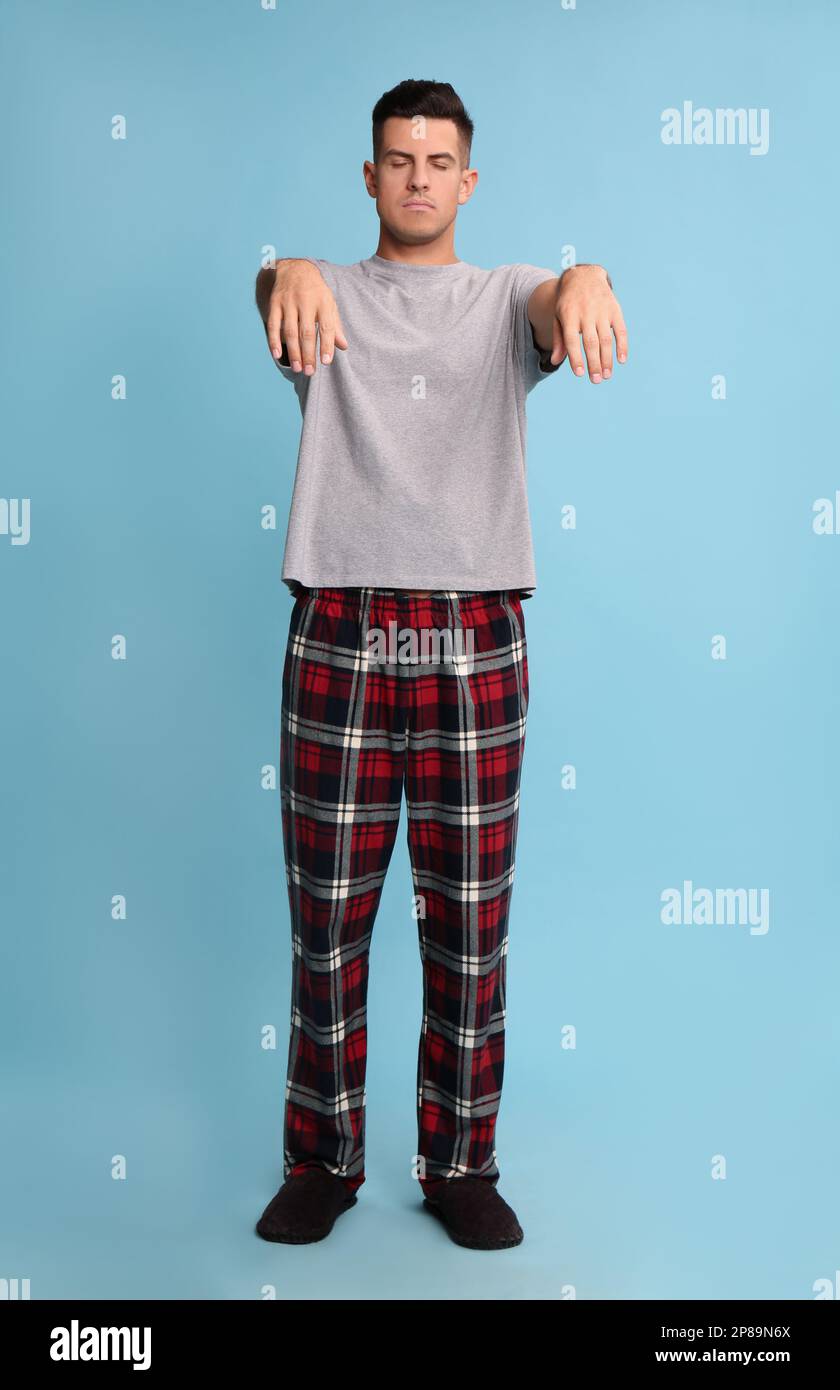 Somnambulist in pajamas on light blue background. Sleepwalking Stock Photo Alamy