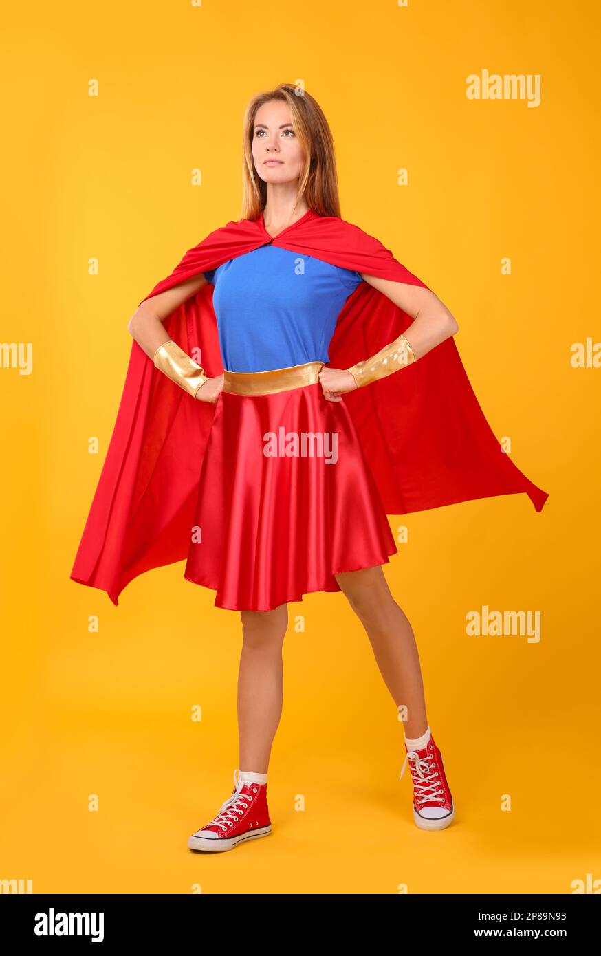 Confident woman wearing superhero costume on yellow background Stock Photo  - Alamy