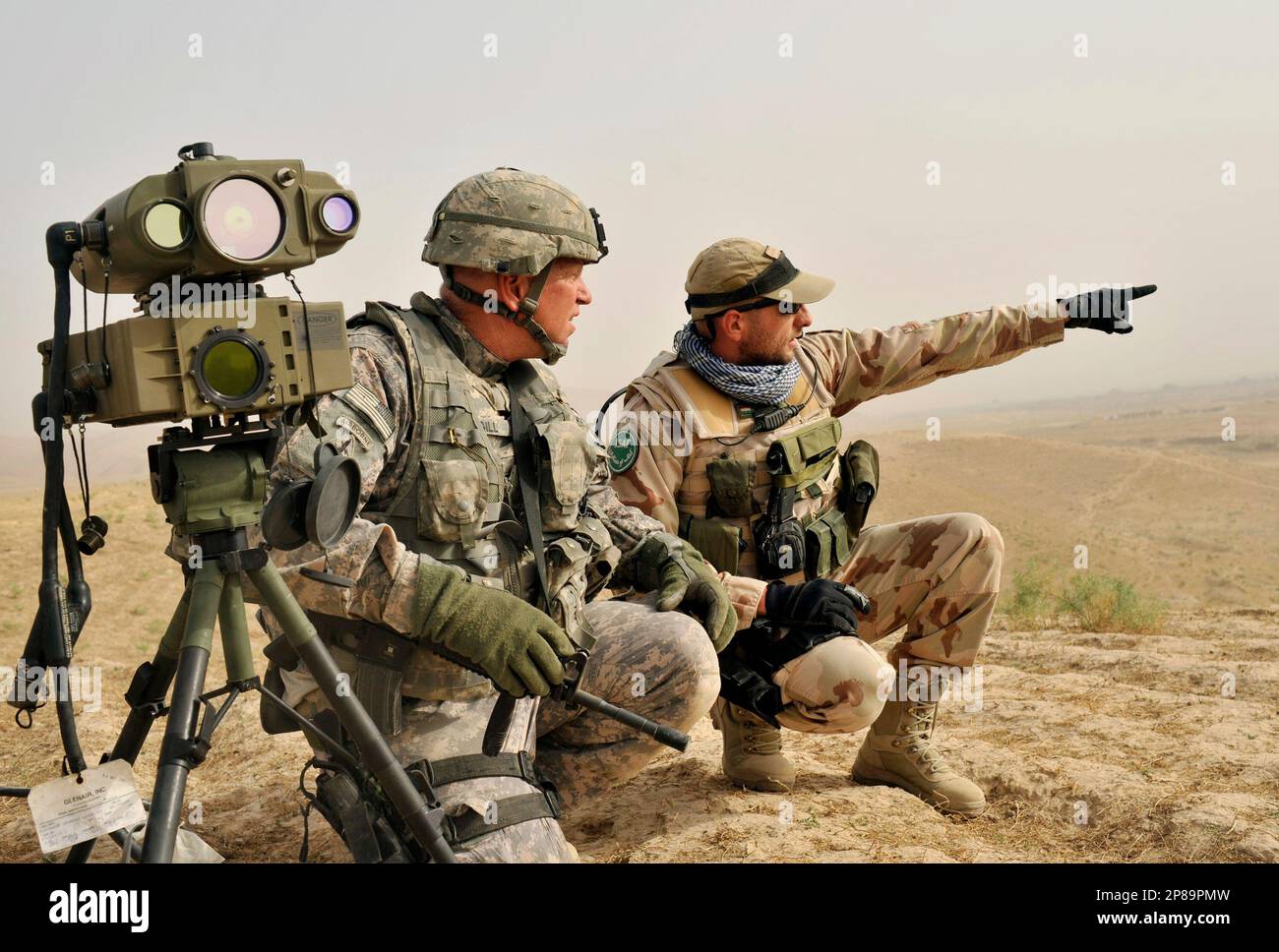 1st Sgt David Gill from Alliance, Oh of the OMLT Team Orthos from 1-145AR  RGT, left, and Hungarian military adviser SFC Otto Szatmari, right, look at  a hill while searching for pro-Taliban