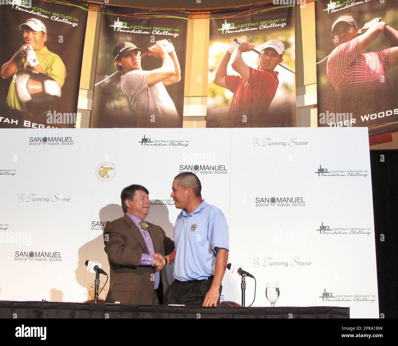 Oneida Nation Representative and CEO Ray Halbritter, left, and Notah Begay  III shake hands after they announce that PGA Tour Professionals Camilla  Villages, Mike Weir and Tiger Woods will play in the