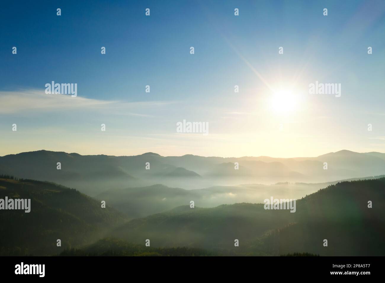 Sun shining over forest in misty mountains. Drone photography Stock ...