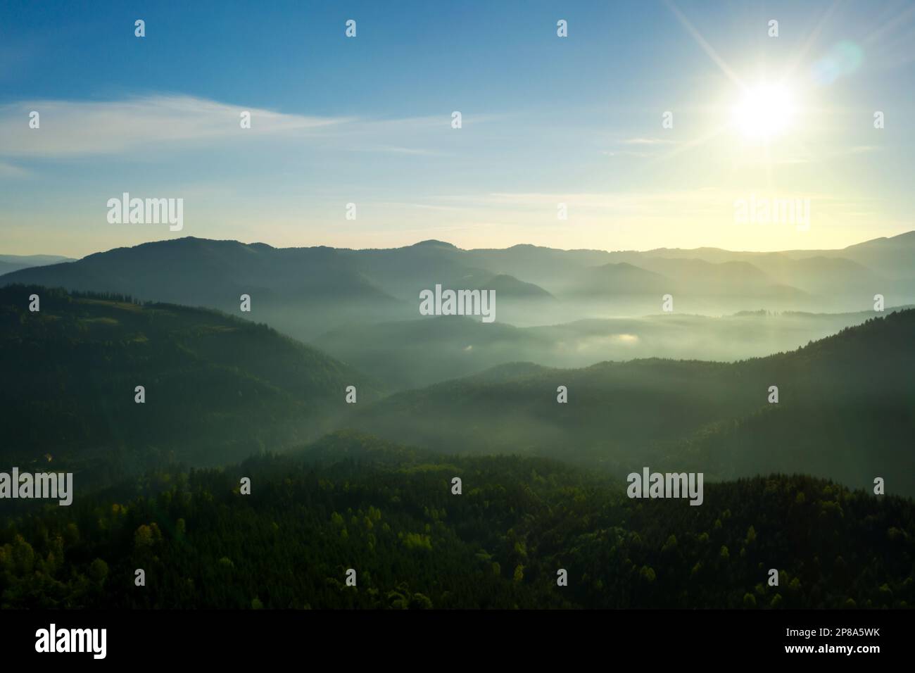 Sun shining over forest in misty mountains. Drone photography Stock ...