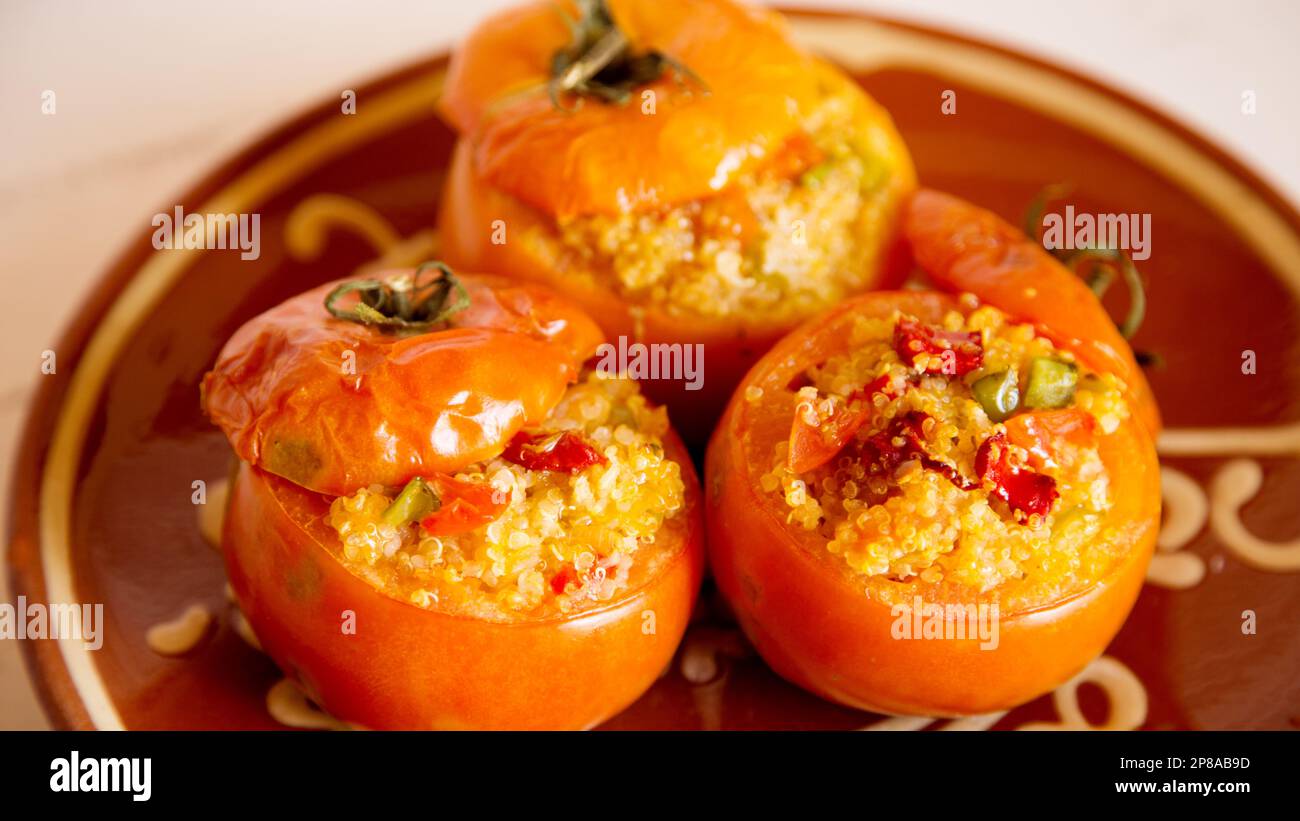 Oven roasted tomatoes stuffed with quinoa and vegetables. vegan recipe. Stock Photo