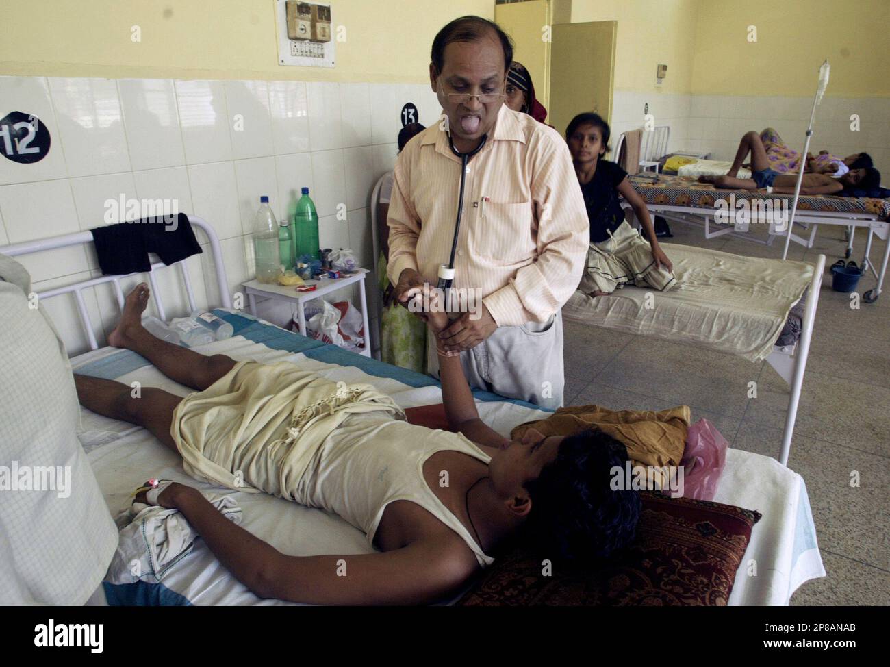 A doctor inspects a diarrhea patient at a hospital in Allahabad, India,  Monday, June 29, 2009. The number of diarrhea cases have increased due to  scorching weather conditions and a lack of