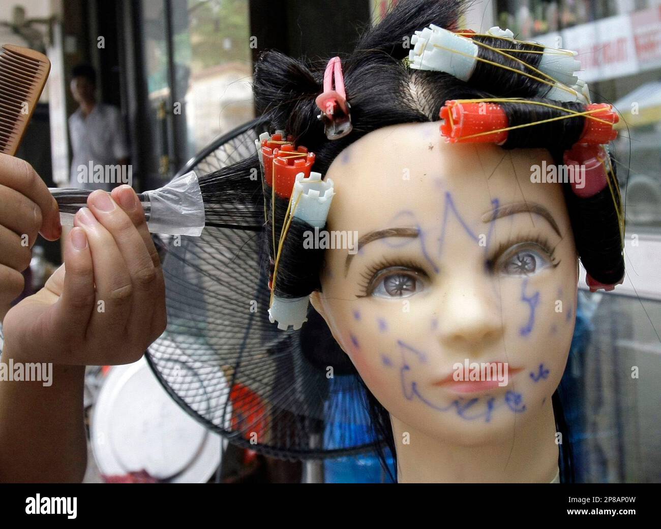 Nguyen Thi Nguyen, a Vietnamese hair dresser trainee, practices using a