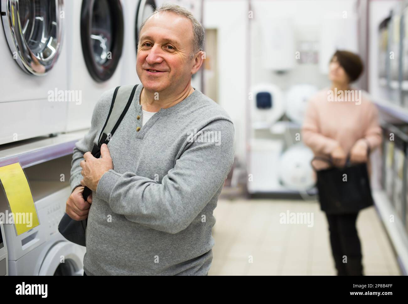 Portrait of a European man standing in the department with washing machines Stock Photo