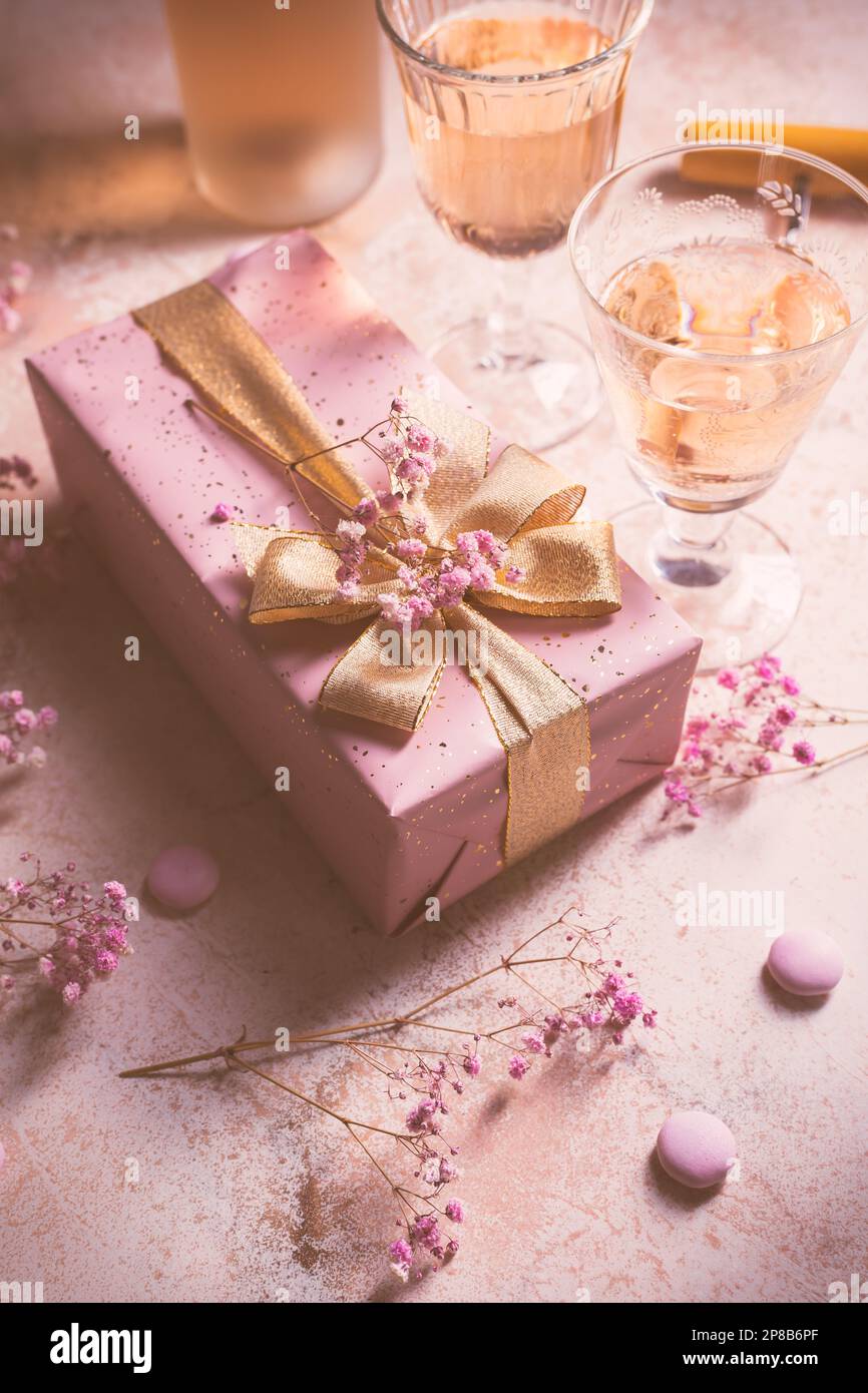 Rose sparkling wine, French macarons and box of chocolates for