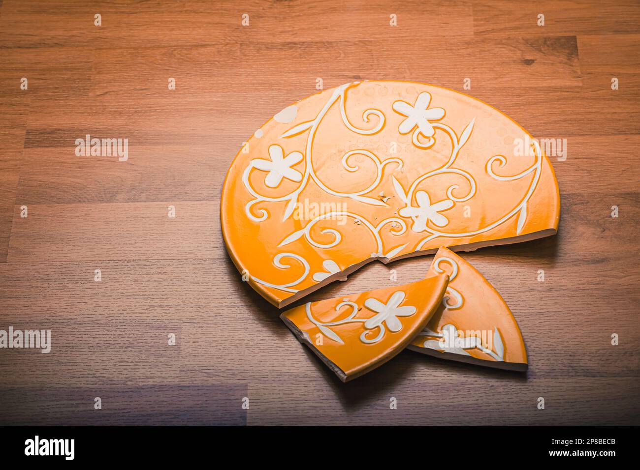 Broken ceramic plate on wooden floor Stock Photo