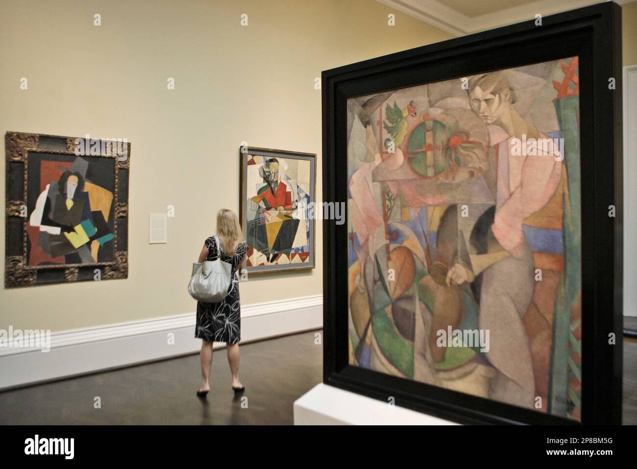 A woman looks at cubist paintings during a preview showing of the art exhibit A woman looks at cubist paintings during a preview showing of the art exhibit