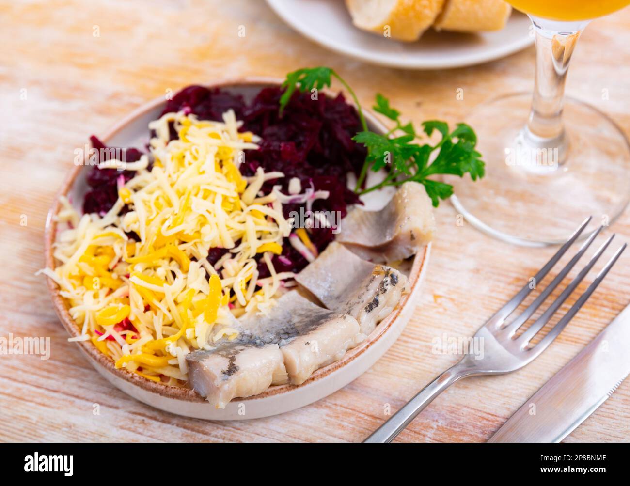 Sliced herring with grated beetroot and cheese served on table Stock Photo