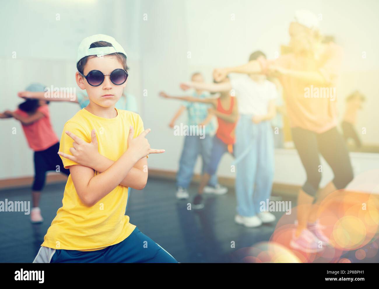 Preteen girl practicing dance movements with group of children Stock ...