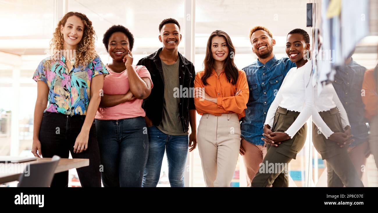 The team you need. Cropped portrait of a group of young designers standing in the boardroom of their office. Stock Photo