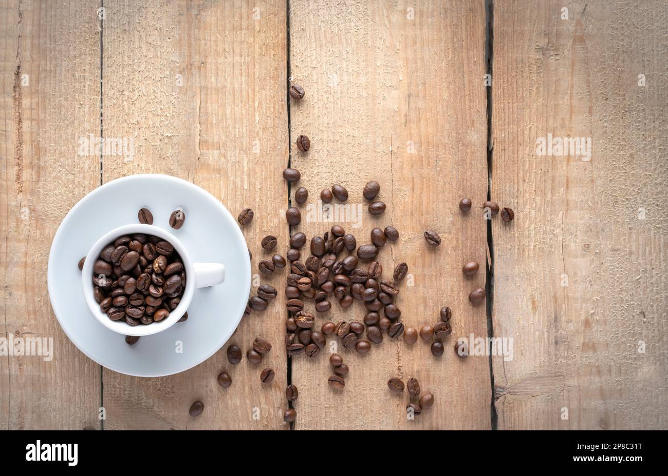 Coffee cup with roasted beans on wooden background, from above Stock Photo