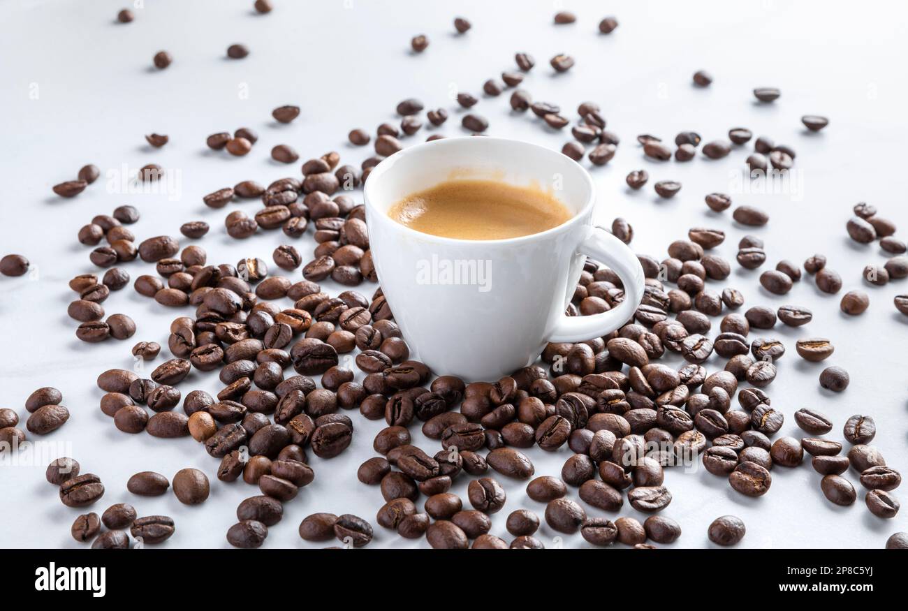 Coffee cup with roasted beans on modern background, from above Stock Photo