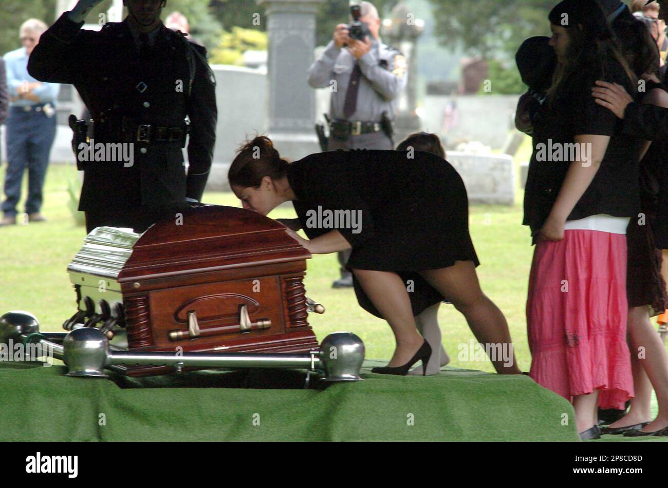 Angela Miller kisses the casket of her husband fallen Trooper Joshua