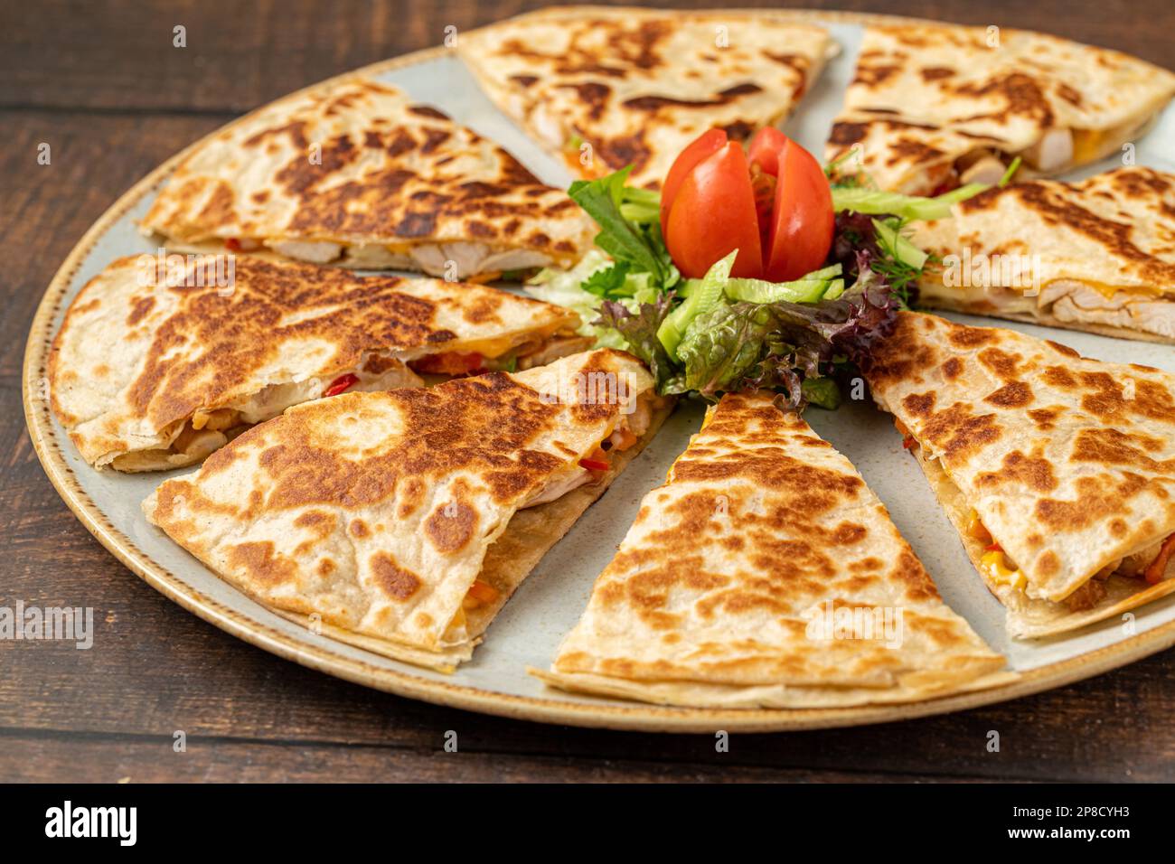 Mexican quesadilla with chicken, cheese and peppers on wooden table Stock Photo