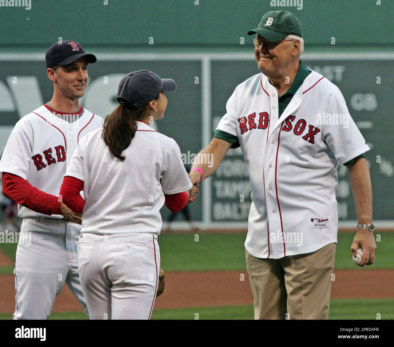 A Boston Red Sox ball girl hands roses to Molly McLaughlin