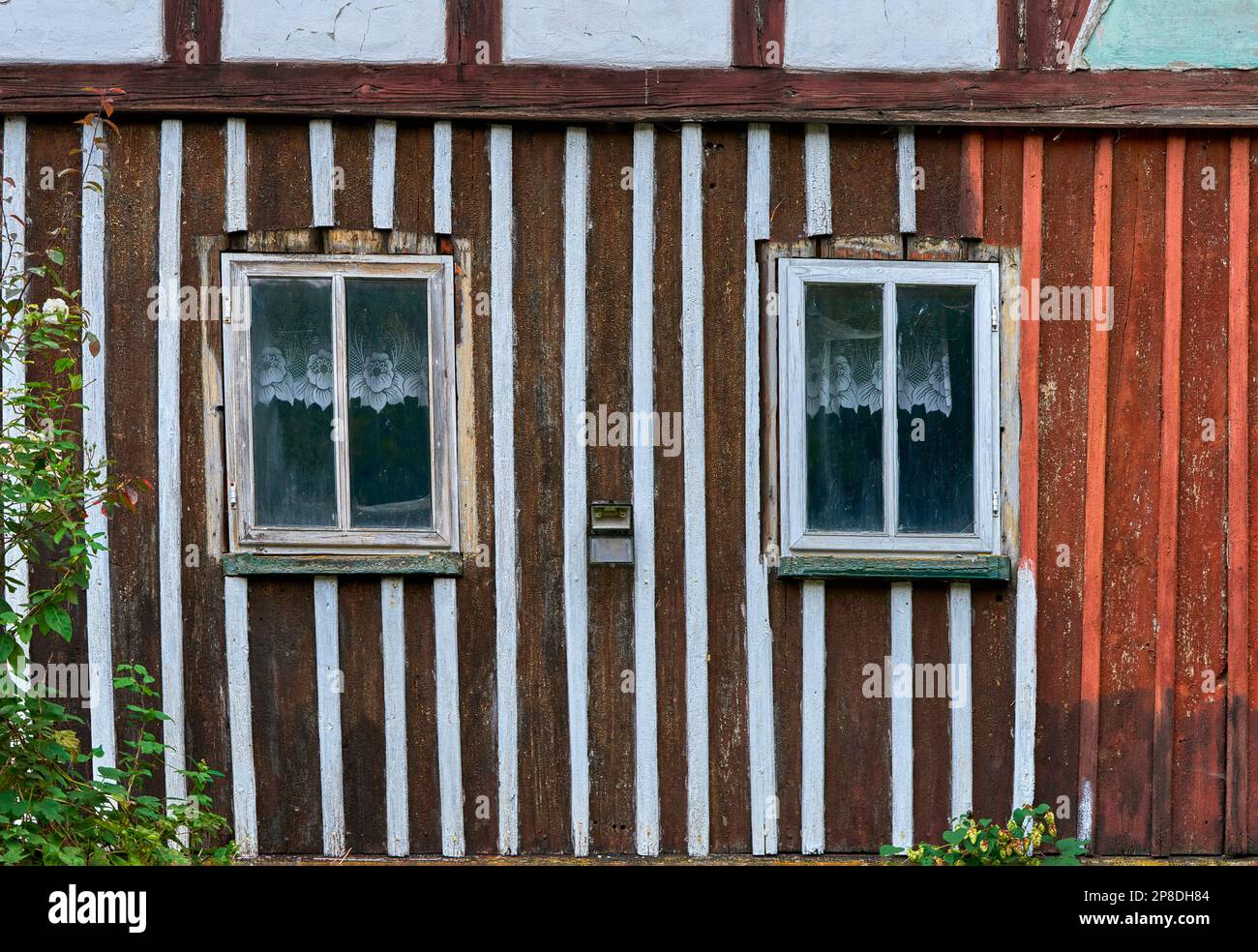 Wooden wall of the old house with the window and lace curtains Stock Photo