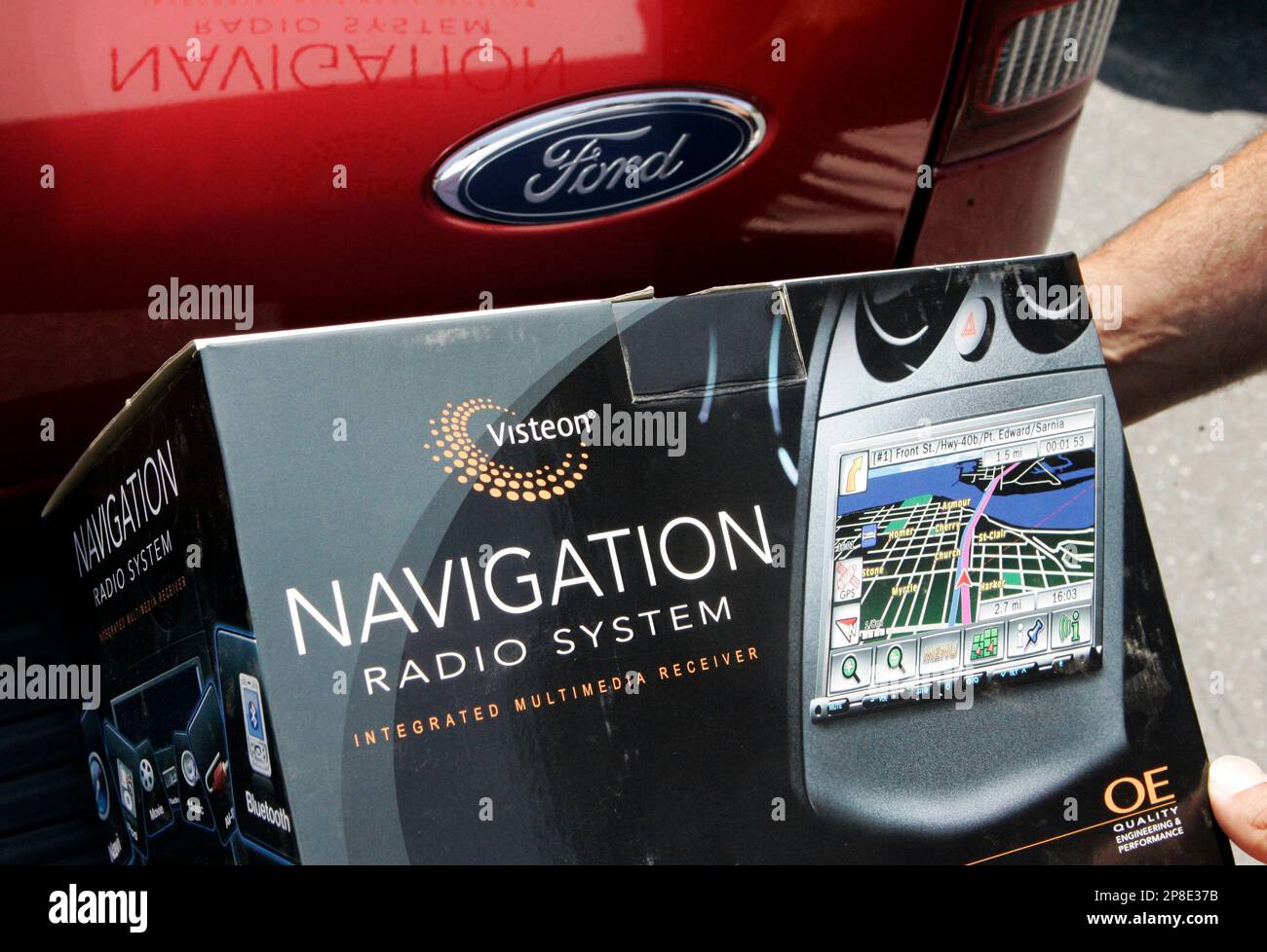 A worker at California Car Sounds poses a Visteon radio navigation system  next to a Ford truck at the shop in Campbell, Calif., Thursday, May 28,  2009. Visteon Corp., the top auto