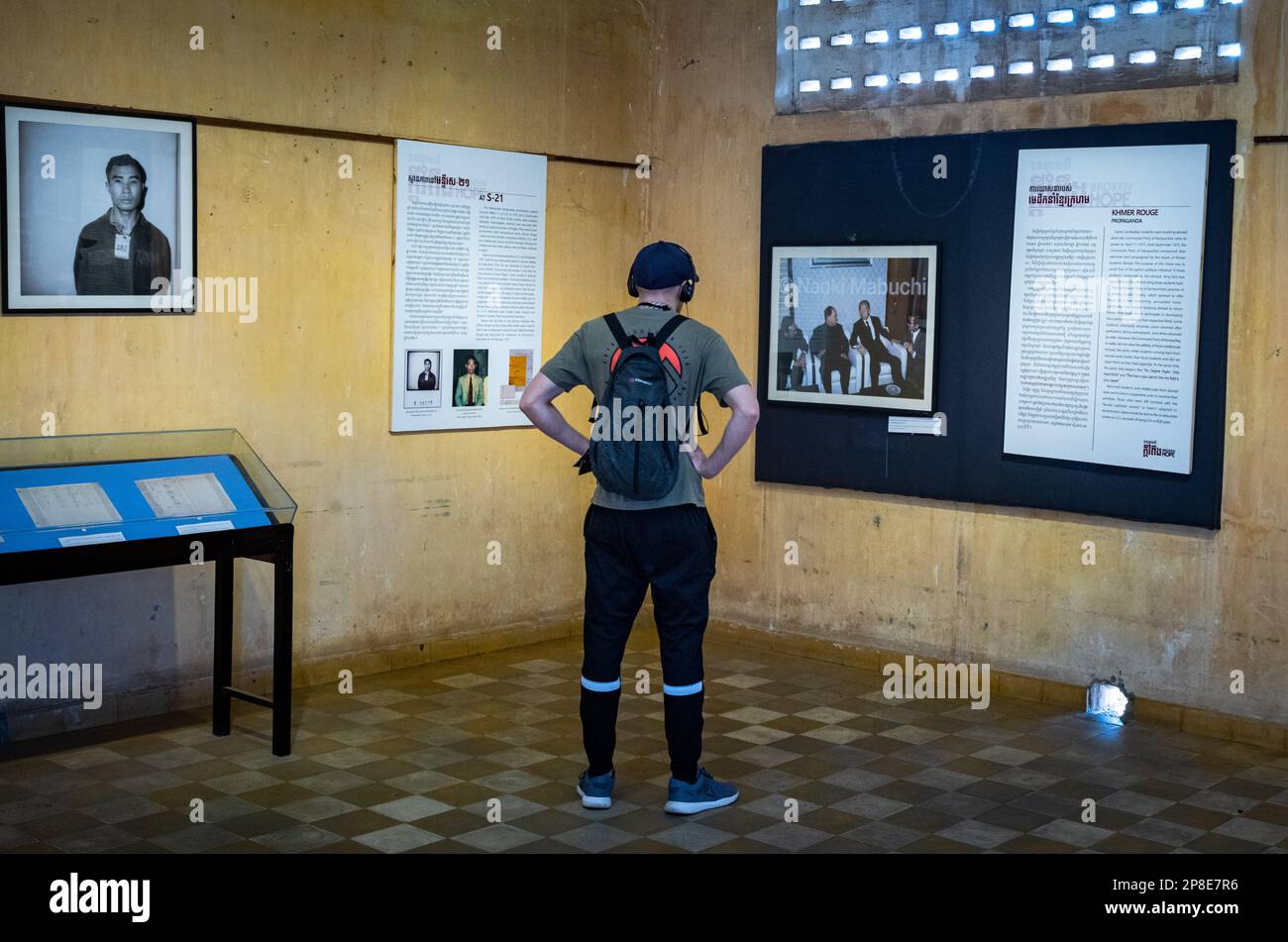 A western tourist looks at displays in a former classroom in the notorious Tuol Sleng S-21 torture and genocide prison museum in Phnom Penh, Cambodia Stock Photo