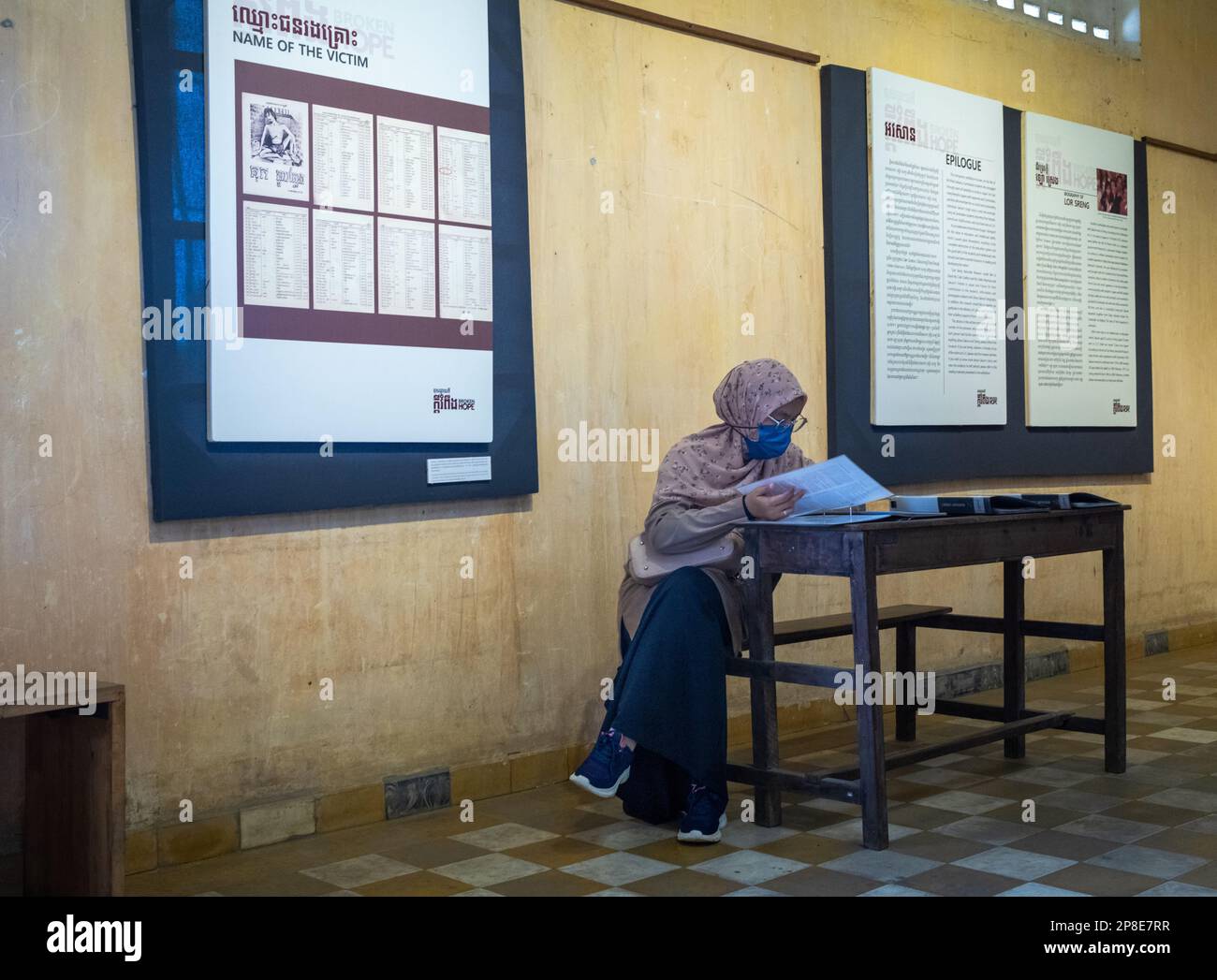 A Cambodian muslim woman reads testimonies in a former classroom in the notorious Tuol Sleng S-21 torture and genocide prison museum in Phnom Penh, C Stock Photo
