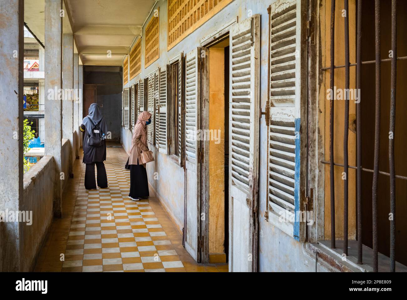 Two Cambodian muslim women look at former classrooms in the notorious Tuol Sleng S-21 torture and genocide prison museum in Phnom Penh, Cambodia. Stock Photo