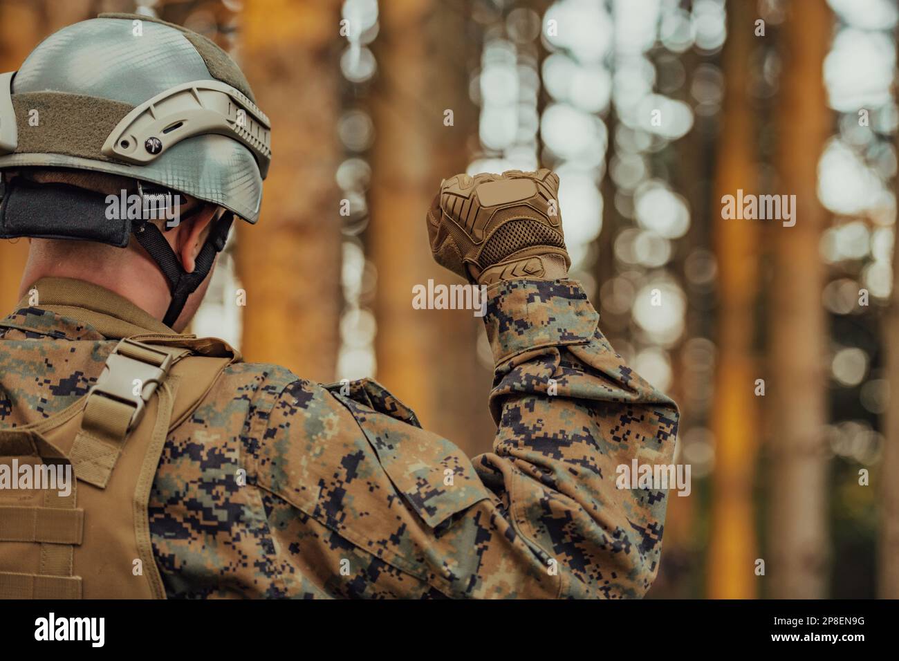 Modern warfare soldier officer is showing tactical hand signals to