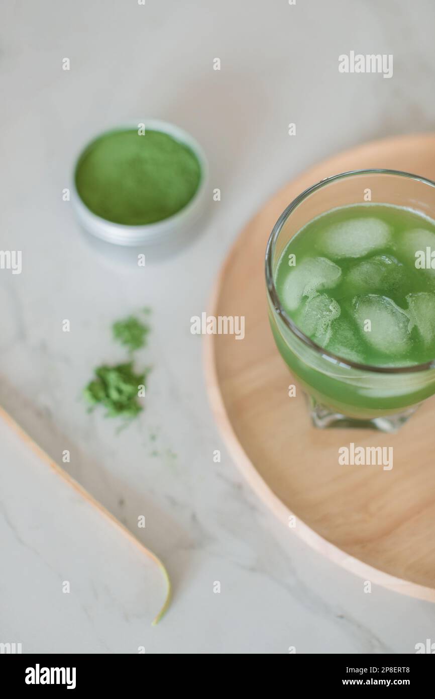 Overhead view of a glass of iced matcha drink, matcha powder and matcha