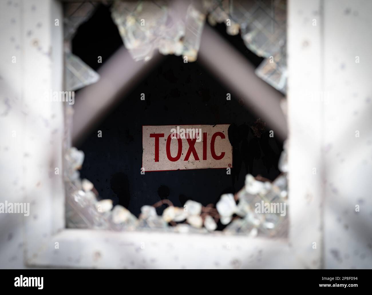 A broken window with small shards of glass scattered across the frame