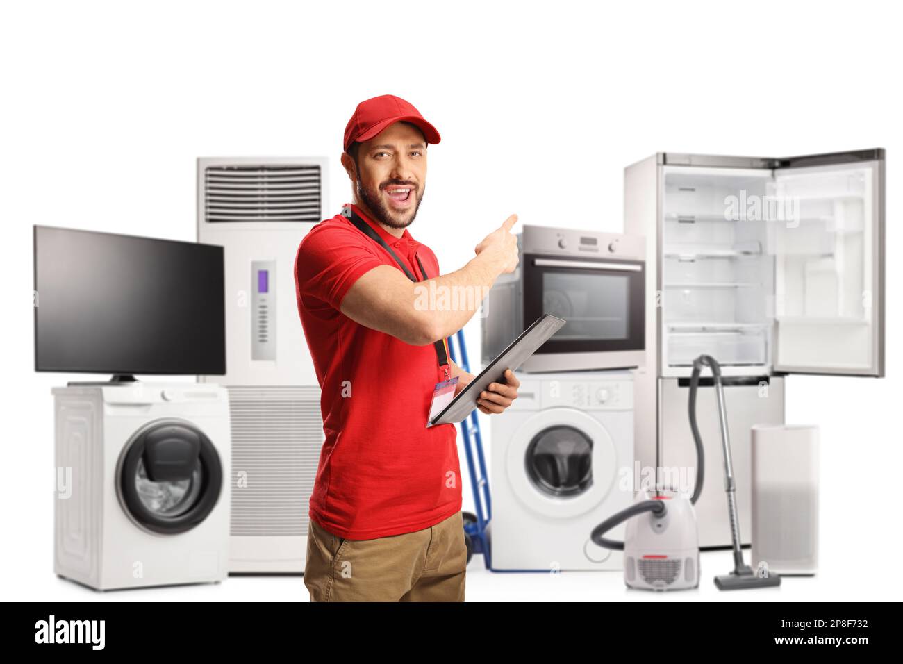 Cheerful male shop assistant holding a clipboard and pointing behind at electrical appliances isolated on white background Stock Photo