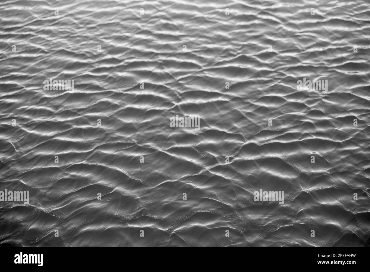 Wavy water texture surface from above in spring. Stock Photo