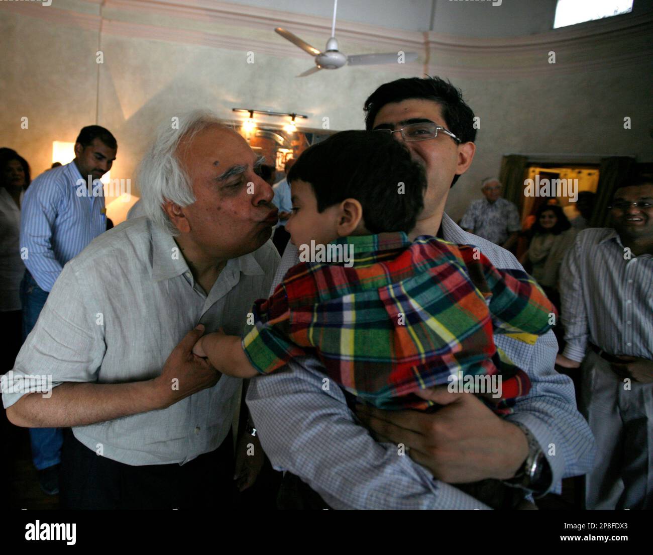 Congress party leader Kapil Sibal, left, kisses his grandson after winning from his constituency in New Delhi, India, Saturday, May 16, 2009. Indian Prime Minister Manmohan Singh declared victory in India's national elections on Saturday, saying voters had given the Congress party-led coalition a "massive mandate." (AP Photo/Mustafa Quraishi) Stock Photo