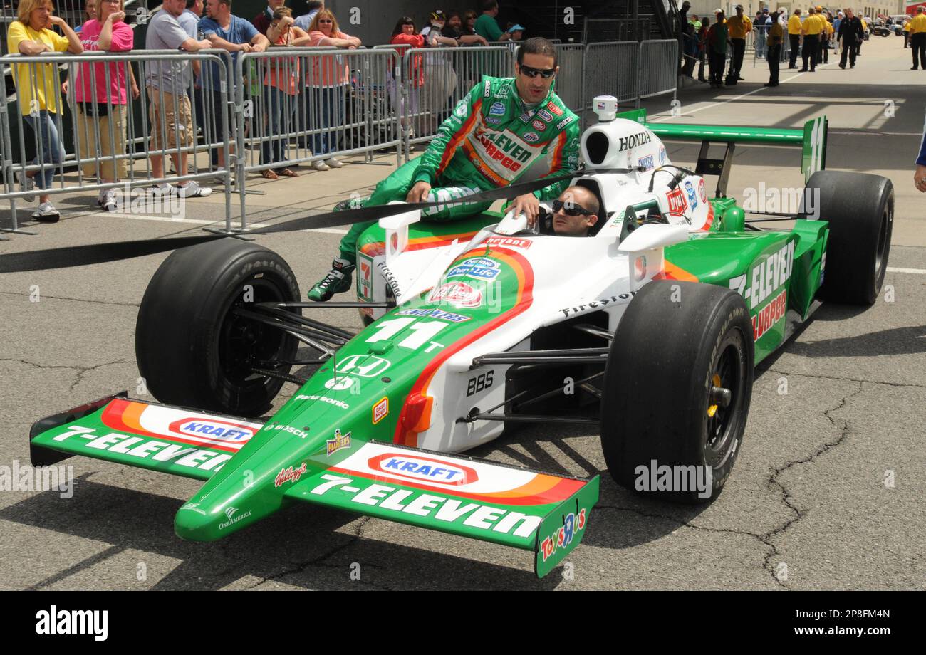 Tony Kanaan, of Brazil, rides on the side of his car as it is towed to ...