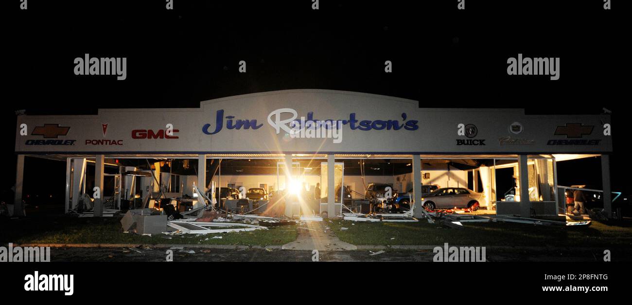 Workers start to cleanup the showroom of the Jim Robertson car
