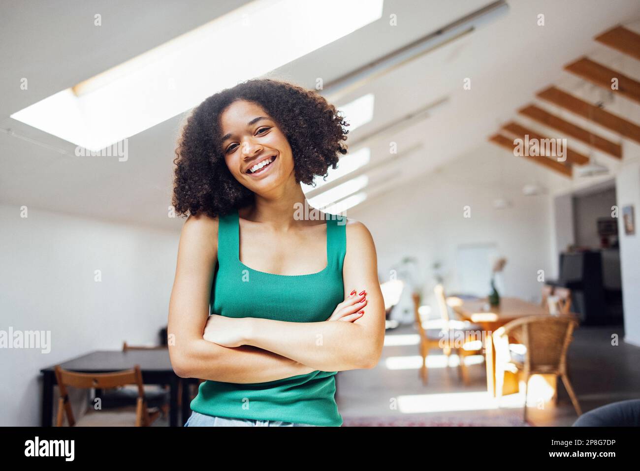 Happy african american woman stands in her living room and smiles ...