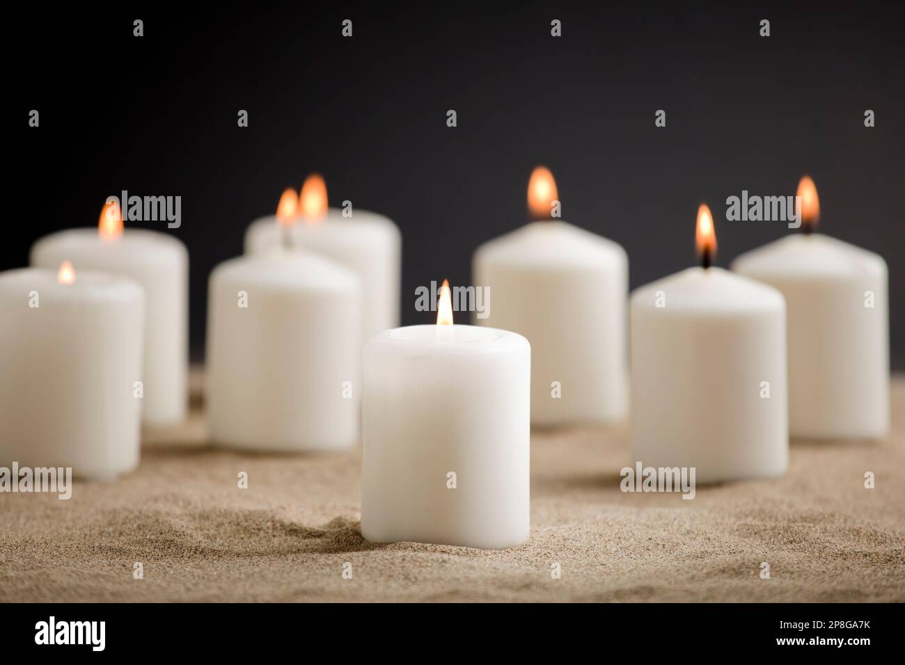 candles with burning flame, in the sand Stock Photo