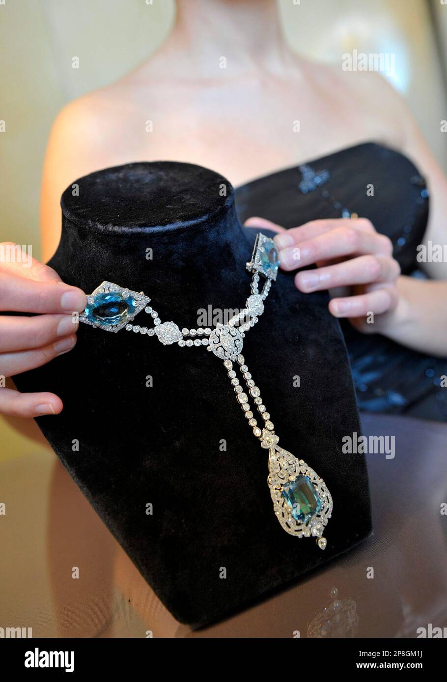A Sotheby's employee displays a 1912 aquamarine and diamond corsage  ornament by Cartier during a preview at Sotheby's in Geneva, Switzerland,  Wednesday, May 6, 2009. It is estimated to fetch some US$100,000-150,000