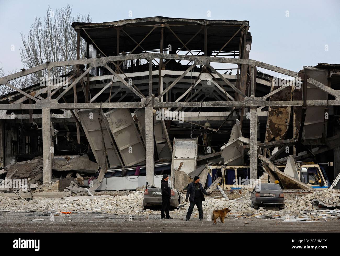 Men stand outside a bus depot damaged by recent shelling in the course of Russia-Ukraine conflict, in the town of Volnovakha in the Donetsk region, Russian-controlled Ukraine, March 9, 2023. REUTERS/Alexander Ermochenko Stock Photo