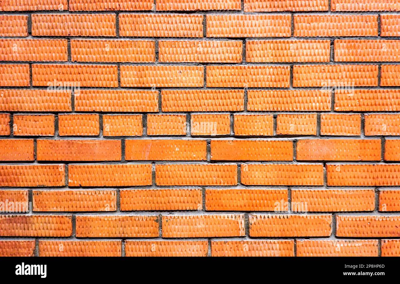 Red brick wall as creative background. Bricks masonry with seams Stock Photo