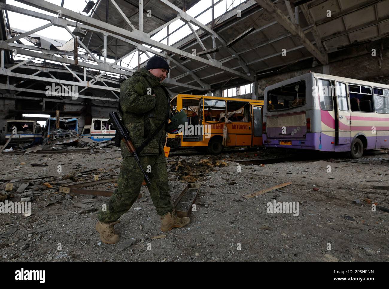 A Russian service member walks through a bus depot damaged by recent shelling in the course of Russia-Ukraine conflict, in the town of Volnovakha in the Donetsk region, Russian-controlled Ukraine, March 9, 2023. REUTERS/Alexander Ermochenko Stock Photo
