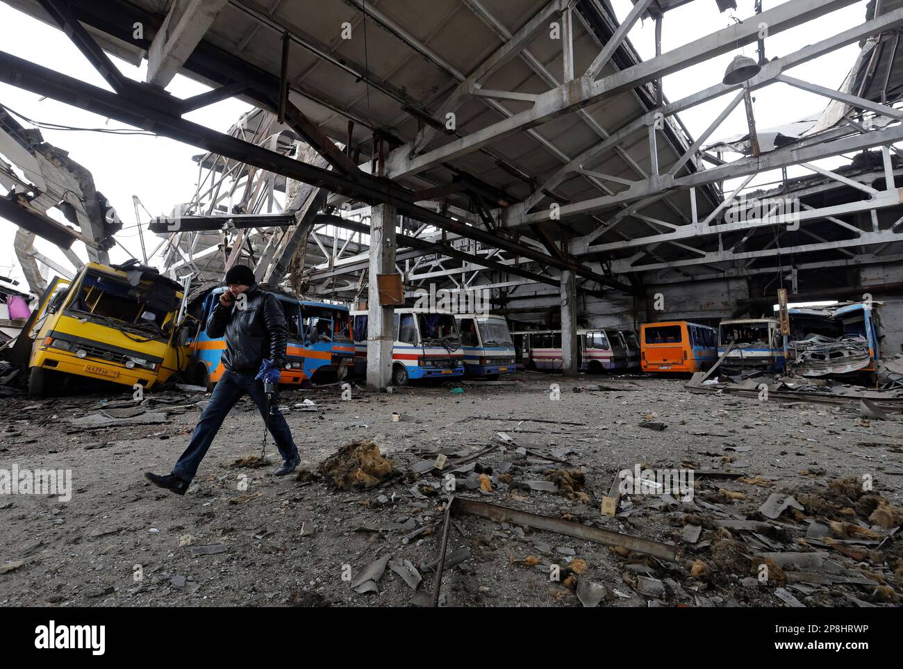 A man walks through the bus depot damaged by recent shelling in the course of Russia-Ukraine conflict, in the town of Volnovakha in the Donetsk region, Russian-controlled Ukraine, March 9, 2023. REUTERS/Alexander Ermochenko Stock Photo
