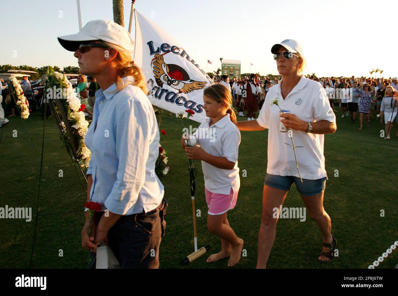 Polo fans carry flowers to throw into a lake in remembrance of the