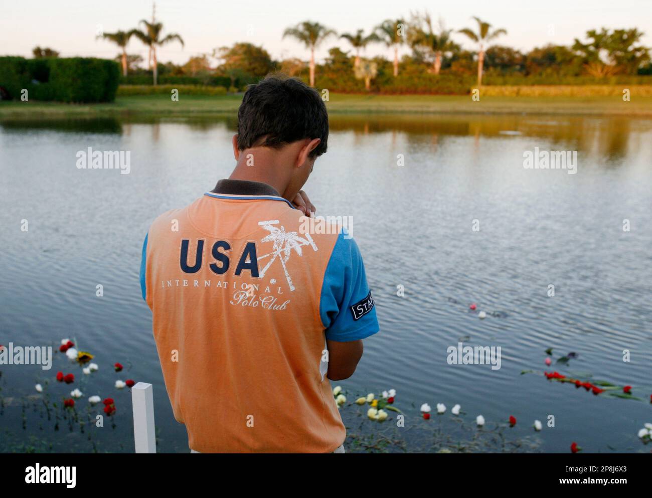 A man pauses where flowers where flowers were thrown in remembrance of