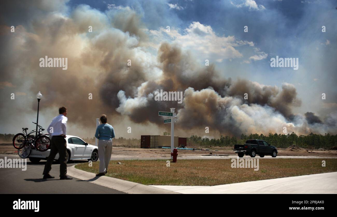 Residents watch from the Glenmoor subdivision as a large fire spreads